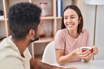 Fototapeta premium Man and woman couple sitting on table drinking coffee at home