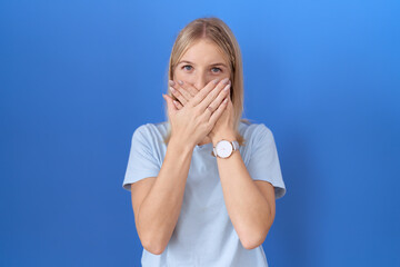 Young caucasian woman wearing casual blue t shirt shocked covering mouth with hands for mistake....