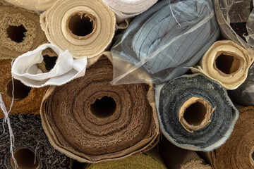 Close-up of stacked rolls of fabric of different materials