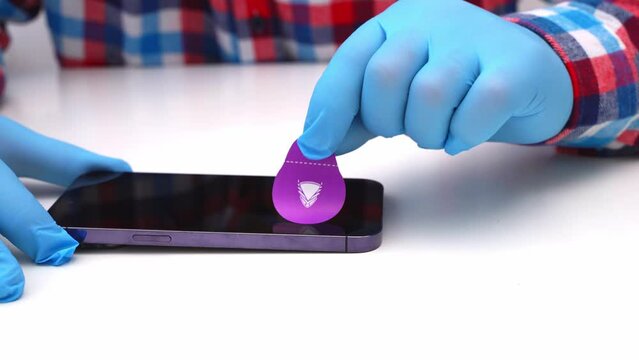 A male master glues a protective glass on a smartphone