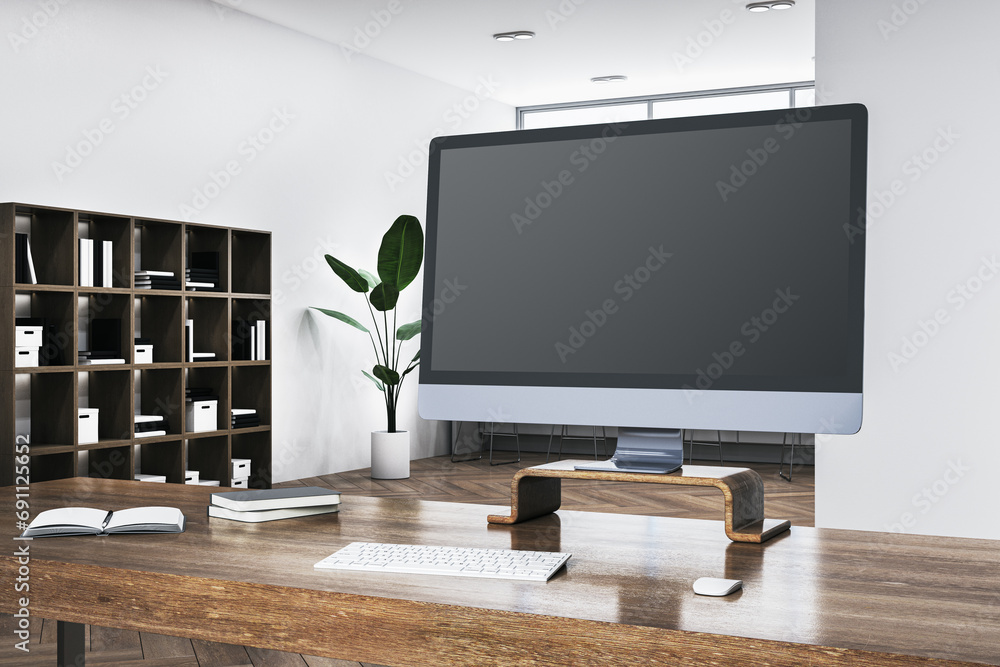 Poster Close up of wooden desk with blank computer monitor, daylight and bookshelf in the background. Mock up, 3D Rendering.
