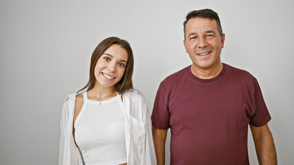 Father and daughter standing together, smiling confidently against an isolated white background,...