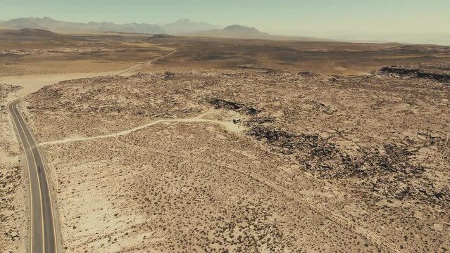 Turistas em furg&atilde;o parados no meio do deserto com apenas uma estrada &agrave; vista.