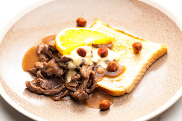 beef mixture with sauce, hazelnuts and orange served with roasted toast