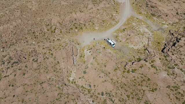 Turistas em furg&atilde;o parados no meio do deserto com apenas uma estrada &agrave; vista.