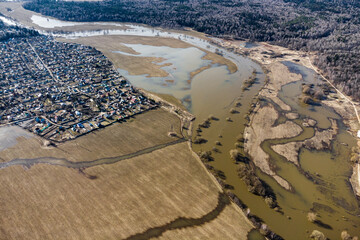 Aerial view of an overflowing river and flooded fields during spring floods