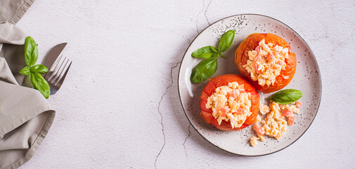 Eggs baked in ripe tomatoes and basil on a plate on the table top view web banner