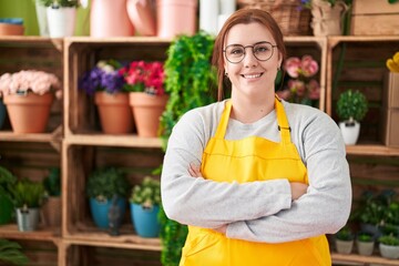 Young beautiful plus size woman florist smiling confident standing with arms crossed gesture at flower shop