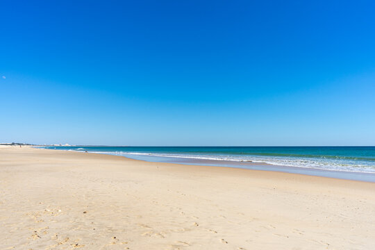 View of idyllic nature landscape with huge beaches and waves crashing on. Manta Rota beach. West Atlantic coast of Algarve region, south of Portugal.