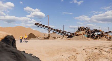 Team of industrial workers inspect sand quarry and check Industry machine for stone crusher, belt...