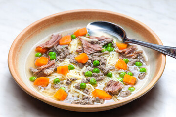 beef broth with green peas, carrot and small meatballs