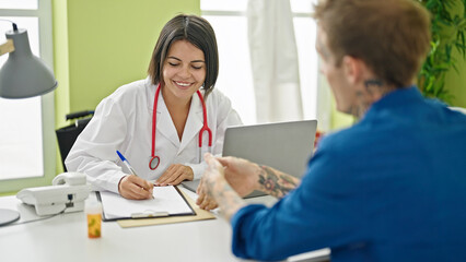 Obraz premium Doctor writing medical report to patient at the clinic