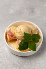 Peach ice cream with strawberry sorbet, decorated with a sprig of mint