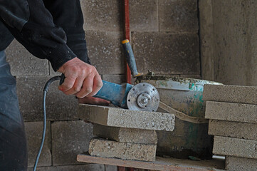 The construction foreman cuts the briquette with a cutting tool.