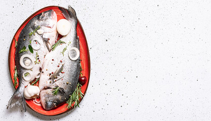 Raw dorado fish with spices and herbs in the cooking pan on white marble background top view, copy...