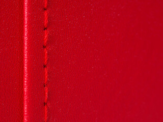 Leather surface of the material with a red seam and a zipper on bags and clothes