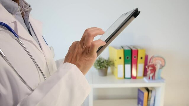 Witness a hospital doctor utilizing a tablet to review a neuroimage, meticulously exploring test results. Immerse yourself in the realm of clinical medical care, neuroimaging, and the vital interplay