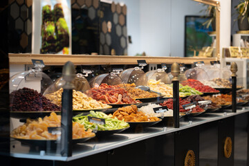 Luxury stand of a dried fruit store. Commercial store display full of bowls with sweet products.
