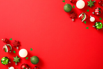 Red Christmas background with ball ornaments in corners. Christmas frame. Flat lay, top view, copy space.