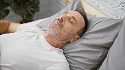 Exhausted, middle age man with grey hair, comfortably resting in the cozy comfort of his bedroom, laid back, relaxing on his soft bed, soundly asleep, escaping the morning rush indoors.