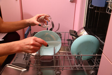 Loading dirty dishes into the dishwasher on the kitchen