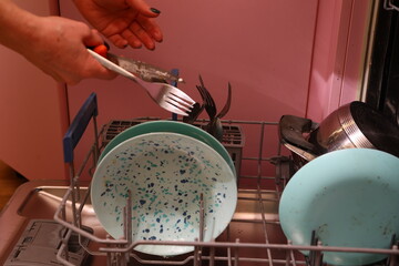 Loading dirty dishes into the dishwasher on the kitchen