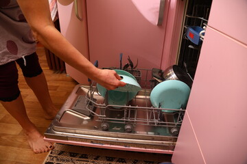 Loading dirty dishes into the dishwasher on the kitchen