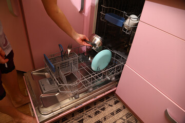 Loading dirty dishes into the dishwasher on the kitchen