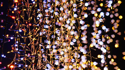 Many wired electric garlands glowing with golden lights