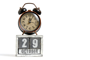 October 29 on wooden calendar with alarm clock white background.
