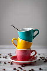 Three coffee cups of different colors stacked with negative space