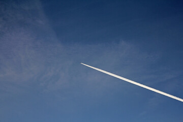 airplane in the sky with Contrails