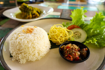 Ayam Betutu, Balinese traditional food. Roasted chicken cooked with cassava leaf and spices served...