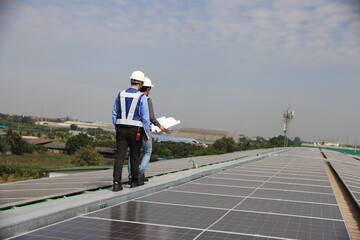 Two men engineer  with plan wearing safety vests talking on the  construction site of the solar roof