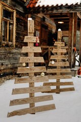 Christmas tree made of wooden boards, Wooden Christmas tree. Outdoor Christmas decoration. Christmas tree stuck in the snow