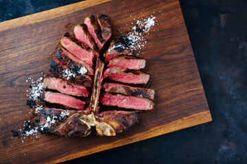Traditional barbecue dry aged wagyu porterhouse beef steak bistecca alla Fiorentina sliced with...