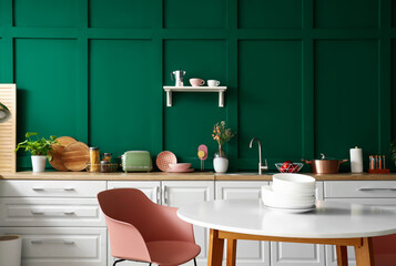 Interior of modern kitchen with white counters and dining table