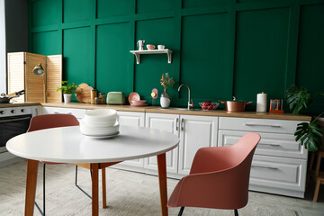 Interior of modern kitchen with white counters and dining table