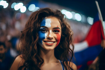 A young girl with the French flag painted on her face cheers for the French team at the stadium during the 2024 Summer Olympics in Paris