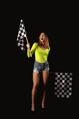 Beautiful young woman with racing flags on black background