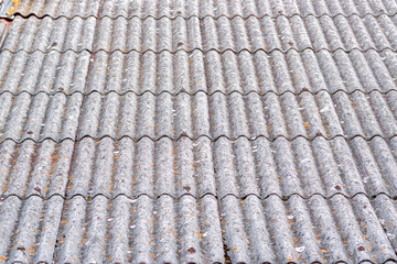 Detail of the old roof of a small family house. Roof covering with dirt and moss.