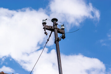 Iron bracket on the roof of the house for the power line. Electrical wires conducted through the...