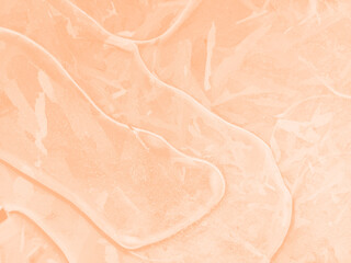 Trendy color of 2024 Peach Fuzz. Natural ice texture. Abstract natural background toned in color of year 2024. Selective focus, blur. Space for text. Top View