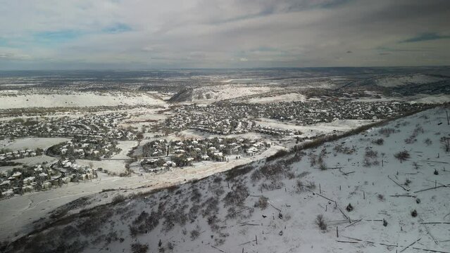 Aerial view of snowy neighborhood near Denver Colorado with mountain side in foreground