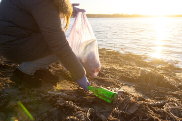 volunteers clean up trash on the beach. empty bottles