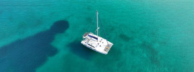 Aerial drone ultra wide photo of beautiful catamaran sailing yacht anchored in tropical exotic...