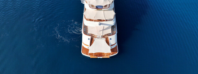 Aerial drone ultra wide top down panoramic photo with copy space of luxury yacht with wooden deck...