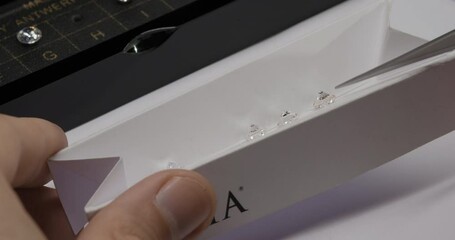 Diamond color grading with master stones. Gemstone laboratory. Gemologist checks diamond quality. Diamond or gem grading and valuation