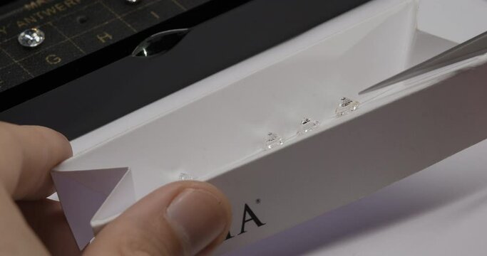 Diamond color grading with master stones. Gemstone laboratory. Gemologist checks diamond quality. Diamond or gem grading and valuation