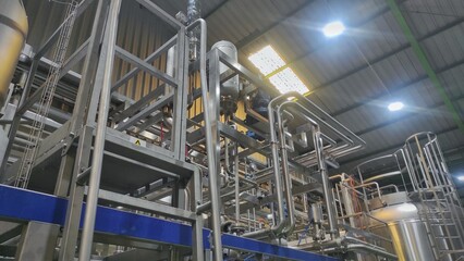 Stainless steel pipe, storage tank and valve in production room of factory
